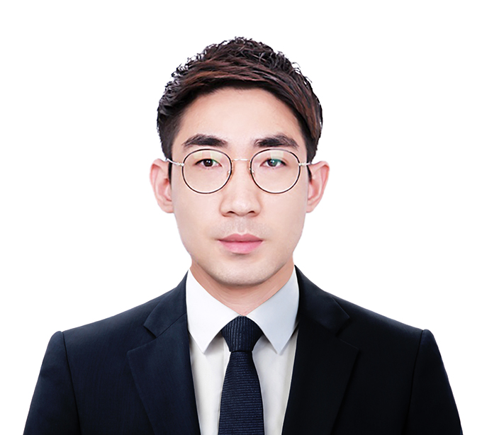 진한 군청색 자켓과 넥타이를 매고 동그란 안경을 쓴 김준환 파트너 변호사의 프로필 상반신 사진