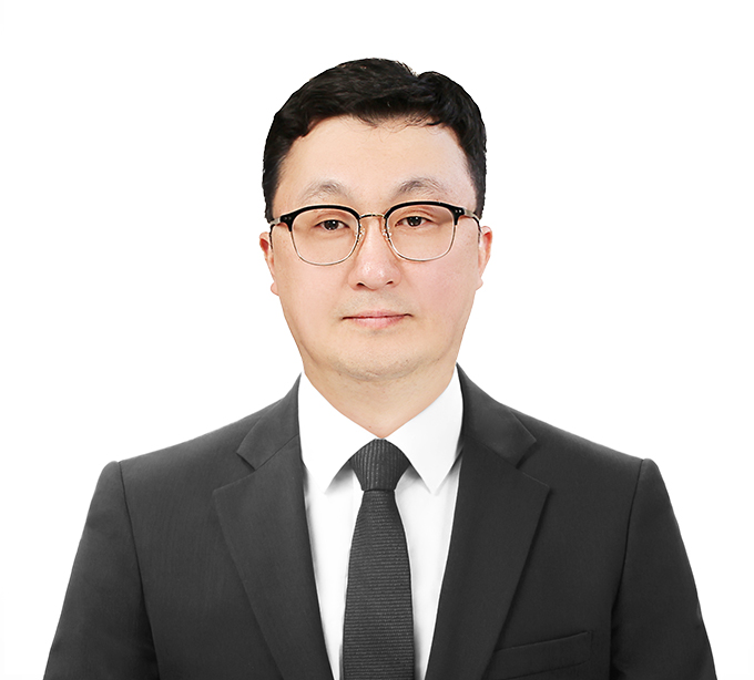 짙은 정장을 입고 와인색 넥타이를 맨 김정환 변호사 상반신 정면 사진